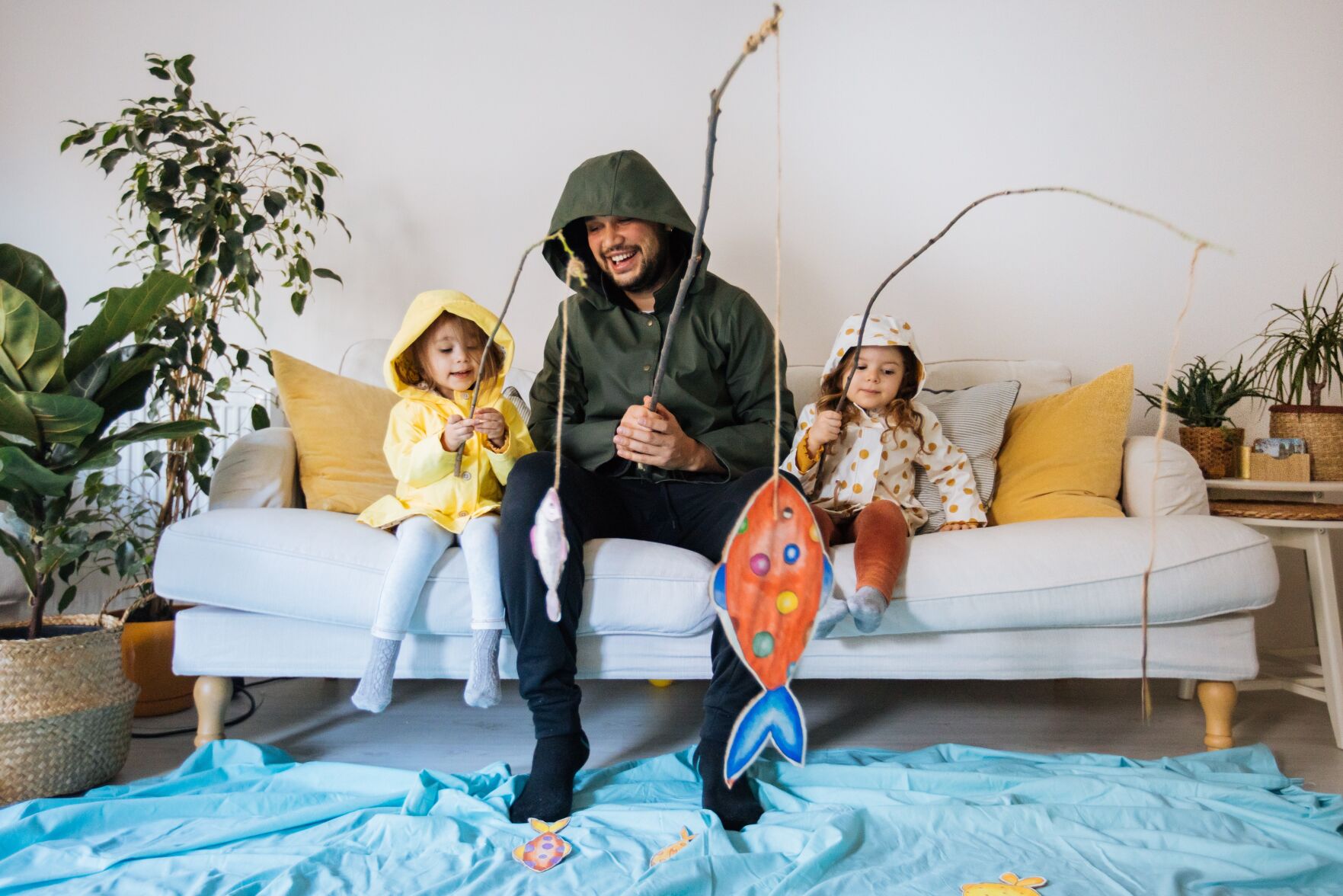 Kids with father playing fishing at home